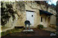 la Roche Clermault, place de la mairie, un banc de pierre devant une habitation troglodyte (67870 octets)