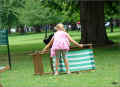 chair-and-girl_st-james-park_07/2009 , une fillette peine à plier et transporter une lourde chaise longue (312253 octets)
